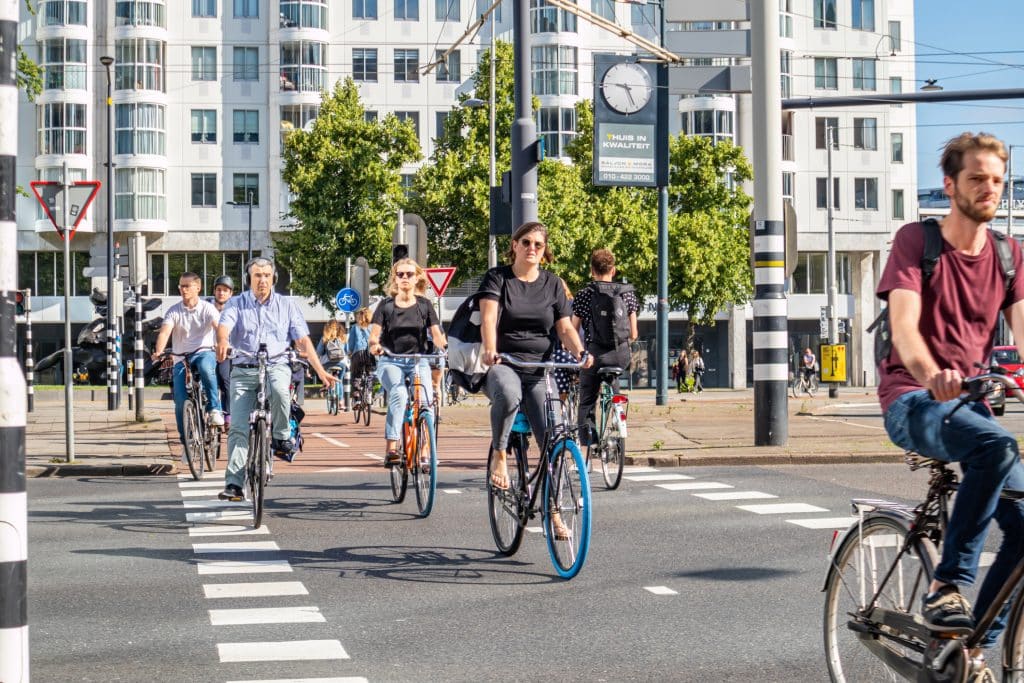 Groep mensen fietst in een stad. 